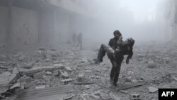 A wounded man is carried following an air strike on the rebel-held besieged town of Arbin, in the eastern Ghouta region on the outskirts of the capital Damascus on January 2, 2018.