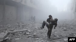 A wounded man is carried following an airstrike on the rebel-held besieged town of Arbin, in the eastern Ghouta region on the outskirts of the capital Damascus, Jan. 2, 2018.