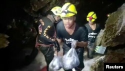 Rescuers carry supplies into the Tham Luang cave complex, where 12 boys and their soccer coach are trapped, in the northern province of Chiang Rai, Thailand, July 5, 2018.