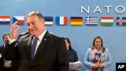 U.S. Secretary of State Mike Pompeo, left, waits for the start of the North Atlantic Council at NATO headquarters in Brussels, April 27, 2018. 