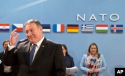 U.S. Secretary of State Mike Pompeo, left, waits for the start of the North Atlantic Council at NATO headquarters in Brussels, April 27, 2018.