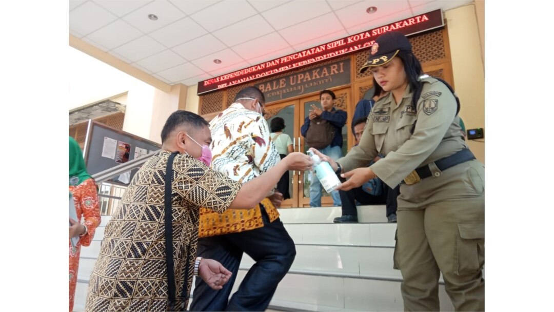 Warga yang mengurus administrasi kependudukan diminta mencuci tangan dengan hand sanitizer yang disediakan Pemkot Solo, Senin, 16 Maret 2020. (Foto: Humas Pemkot Surakarta)