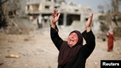 2014年8月1日，一名妇女在拜特哈嫩镇自家被毁屋子前情绪激动。目击者说，在以色列对加沙北部的进攻的炮击和空袭中该镇遭到重创。