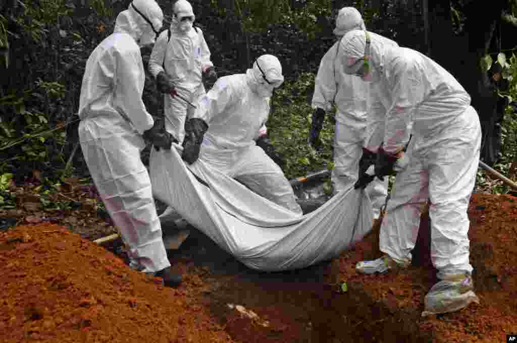 Des agents de service de santé enterrent la dépouille d&#39;un malade d&#39;Ebola mort au Liberia. (AP Photo/Abbas Dulleh) 