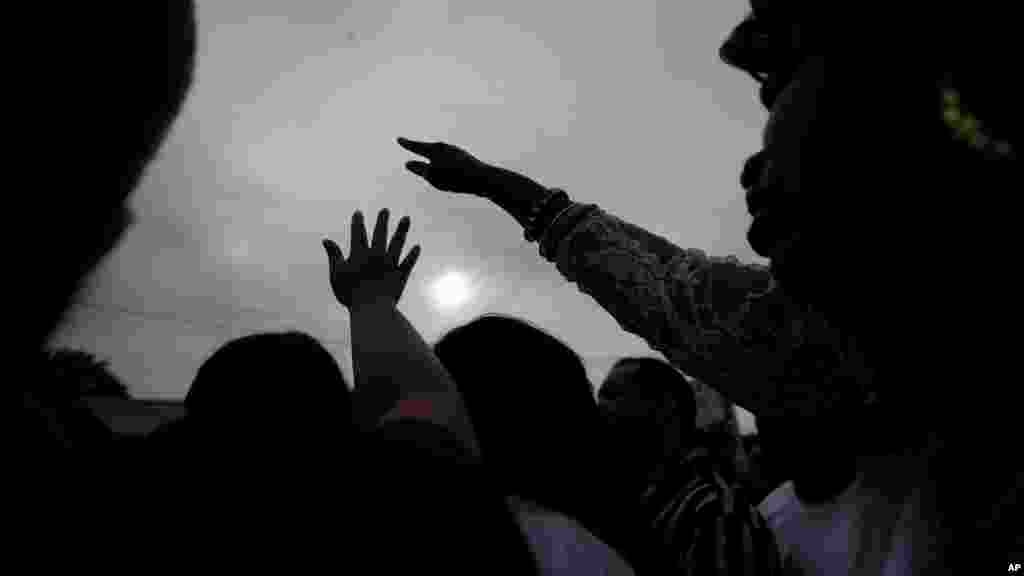 Les gens tiennent leurs mains en prière à une veillée en dehors de la Triple de dépanneur à Baton Rouge, La., Le mercredi 6 Juillet, ici 2016.