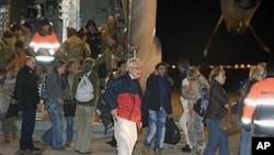 Evacuees from Libya step out of an Italian Air Force C-130 military plane at Rome's Pratica di Mare military airport, February 24, 2011