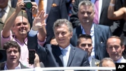 Argentina's President Mauricio Macri waves to followers after he took the oath of office in Congress in Buenos Aires, Dec. 10, 2015. 
