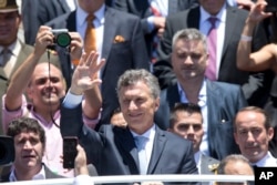 FILE - Argentina's President Mauricio Macri waves to followers as he leaves Argentina's Congress after he was sworn in, in Buenos Aires, Dec. 10, 2015.