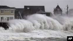 Ombak menghantam dinding pantai dan bangunan di Hull, Massachusetts (7/11). (AP/Steven Senne)