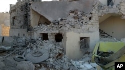 This photo provided by the Shafak Charity Organization, which has been authenticated based on its contents and other AP reporting, shows shows the badly damaged exterior of a medical facility dedicated to women after it was hit by four airstrikes that also killed two civilians in northern Idlib province, Syria, Nov. 25, 2016.