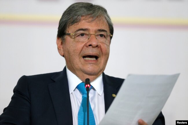 FILE - Colombia's Foreign Affairs Minister Carlos Holmes Trujillo reads a statement after a meeting of the Lima Group in Bogota, Colombia, Feb. 25, 2019.