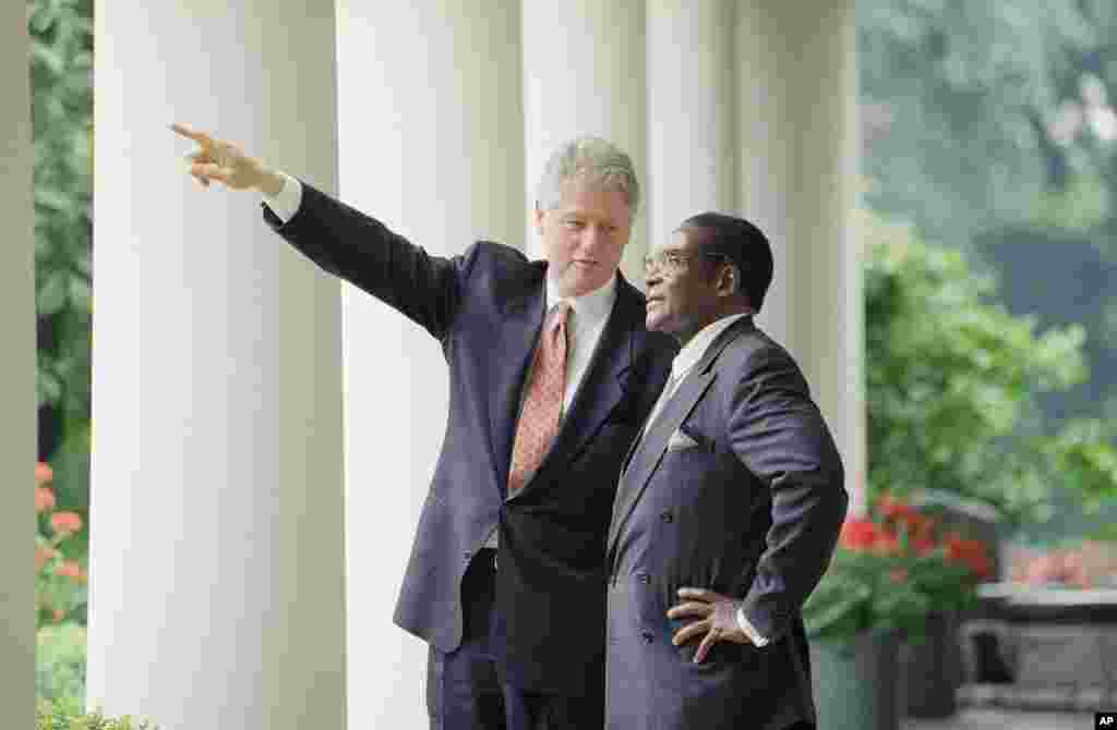 President Bill Clinton gestures while talking to Zimbabwe Prime Minister Robert Mugabe in the Colonnades of the White House, Washington, May 18, 1995, after their Oval Office meeting.