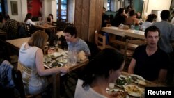 유럽 13개 도시에서 세계 난민의 날을 기념하는 난민 음식축제가 열린 가운데, 19일 그리스 아테네의 한 식당에서 손님들이 시리아 전통 음식을 먹고 있다.