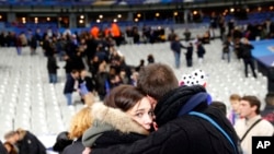 Fans comfort each other after descending onto the playing field in Stade de France stadium at the end of the friendly soccer match between France and Germany in Saint Denis, outside Paris, Nov. 13, 2015, the night of the terror attacks.