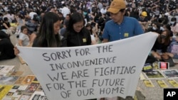 Người biểu tình Hồng Kông với biểu ngữ xin du khách thứ lỗi vì sự bất tiện gây ra từ các cuộc biểu tình. 