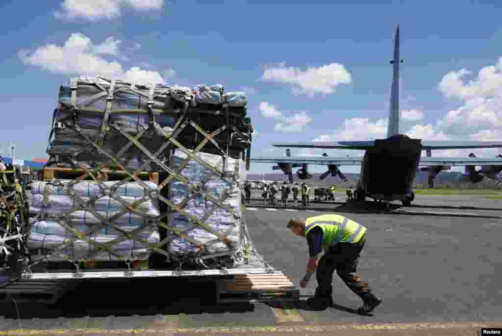 Petugas menurunkan pasokan-pasokan dari pesawat Selandia Baru C130 di Port Vila, Vanuatu (18/3).&nbsp;​(Reuters/Edgar Su)