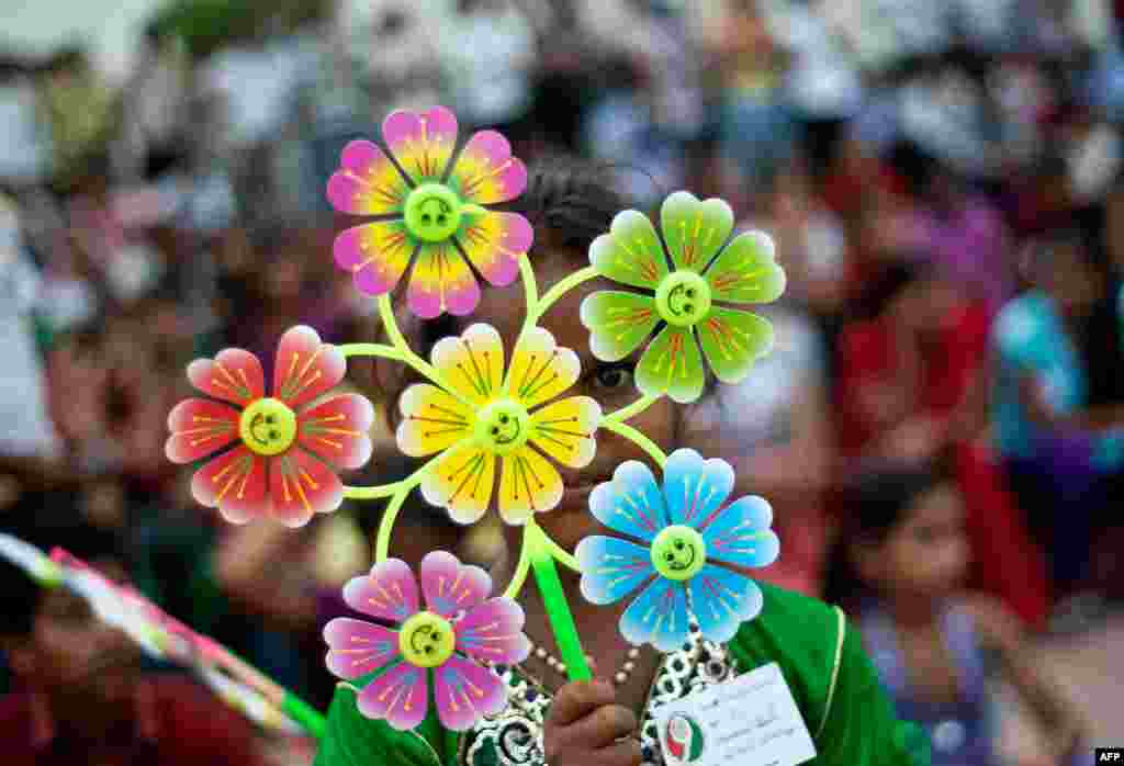 A young Indian girl holds a flower-shaped pinwheel, with each petal representing a child death caused by malnutrition, during a Global Day of Action against Global Hunger event in New Delhi. 
