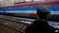 A railroad worker stands by the first train decorated with letters that read "Kosovo is Serbian" written in twenty languages departing from Belgrade to Mitrovica, Kosovo, Jan. 14, 2017.