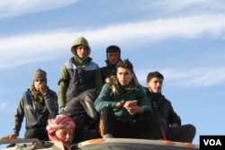 Young men, like this group on top of an army truck fleeing Mosul, say more men got married under IS, in fear that they would not be able to follow IS rules and get caught talking or texting with a woman. (H. Murdock/VOA)