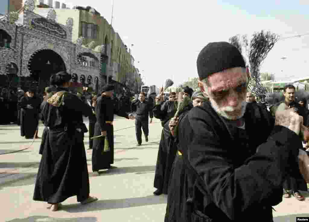 Para penganut Syiah memukuli diri mereka dengan rantai besi saat ambil bagian dalam prosesi Ashura di Karbala, Irak (11/11).