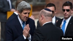 U.S. Secretary of State John Kerry, left, greets Israeli official before wreath-laying ceremony marking Israel's annual day of Holocaust remembrance, Yad Vashem, Jerusalem, April 8, 2013.