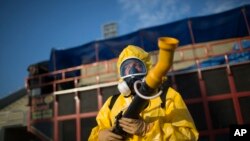 FILE - A health worker stands in the Sambadrome as he sprays insecticide to combat the Aedes aegypti mosquitoes that transmit the Zika virus, in Rio de Janeiro, Brazil, Jan. 26, 2016.