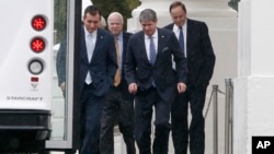 Republican senators walk in the rain back to their bus at the North Portico of the White House in Washington, Oct. 11, 2013.