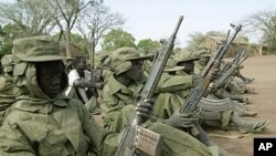 Child soldiers of the rebel Sudan People's Liberation Army (SPLA) wait for their commander at a demobilization ceremony at their barracks in Malou, southern Sudan Sunday, February 25, 2001 (file photo).