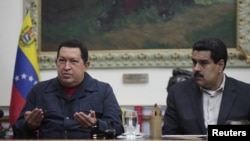 Venezuelan President Hugo Chavez speaks next to Vice President Nicolas Maduro during a national broadcast at Miraflores Palace in Caracas December 8, 2012. Chavez said on Saturday he would undergo another cancer operation in the coming days after doctors 