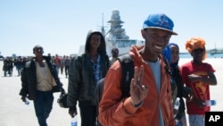 2015年4月22日，一名获救的移民在到达意大利西西里走下意大利海军舰只的时候作出了胜利的手势。
