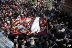 FILE - Kashmiri villagers shout slogans as they carry the body of a civilian Suhail Ahmad during his funeral at Pinjura village 52 kilometers south of Srinagar, Indian-controlled Kashmir, March 5, 2018.