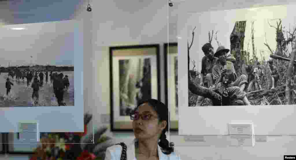 Seorang perempuan memandang foto yang diambil oleh Doan Cong Tinh pada perang Vietnam, pada sebuah pameran foto berjudul &quot;Reporters de guerre,&quot; (Wartawan perang) di pusat budaya Perancis di Hanoi. Pameran ini memperlihatkan lebih dari 40 foto yang diambil oleh empat fotografer Vietnam&nbsp;​Doan Cong Tinh, Chu Chi Thanh, Mai Nam dan Hua Kiem. Vietnam merayakan 40 tahun jatuhnya Saigon, 30 April mendatang.