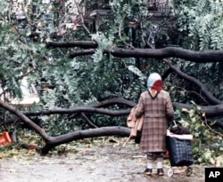 FILE - A woman finds her passage blocked by fallen trees in London, Oct. 16, 1987, after overnight storms with hurricane-force winds caused widespread damage.