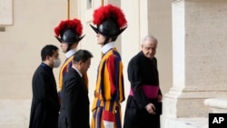 South Korea's President Moon Jae-in, center, is greeted by Head of the Papal Household, Mons. Leonardo Sapienza, right, as he arrives for a meeting with Pope Francis at the Vatican, Oct. 29, 2021.