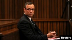 Olympic and Paralympic track star Oscar Pistorius sits in the dock during his trial for the murder of his girlfriend Reeva Steenkamp, at the North Gauteng High Court in Pretoria, March 25, 2014. 
