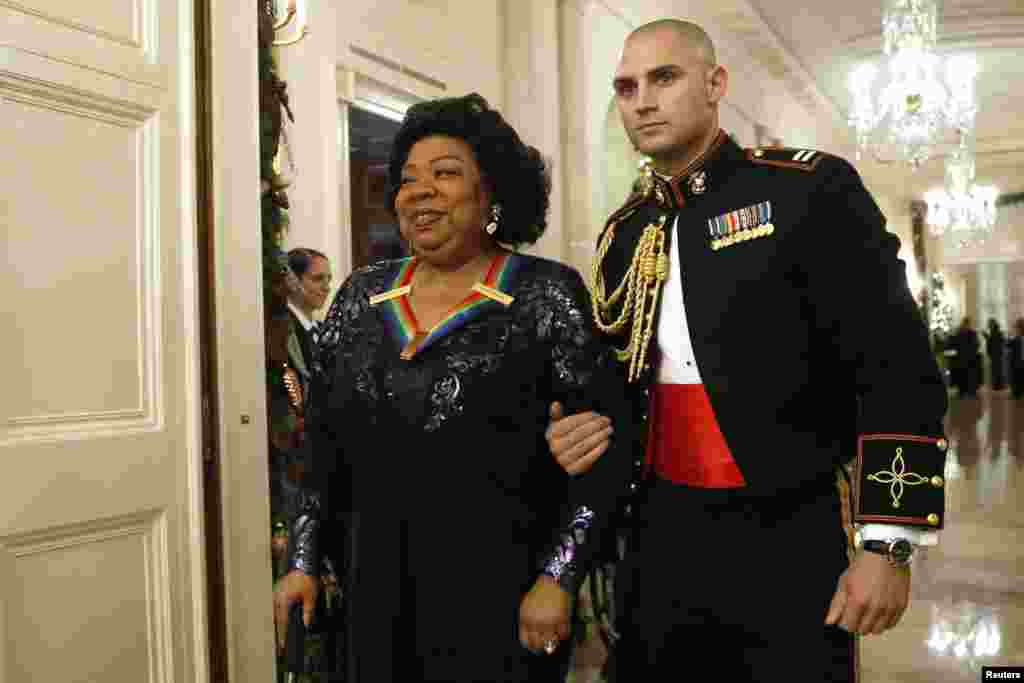 Opera singer Martina Arroyo is escorted as she arrives with fellow 2013 Kennedy Center honorees for a reception at the White House, Dec. 8, 2013.