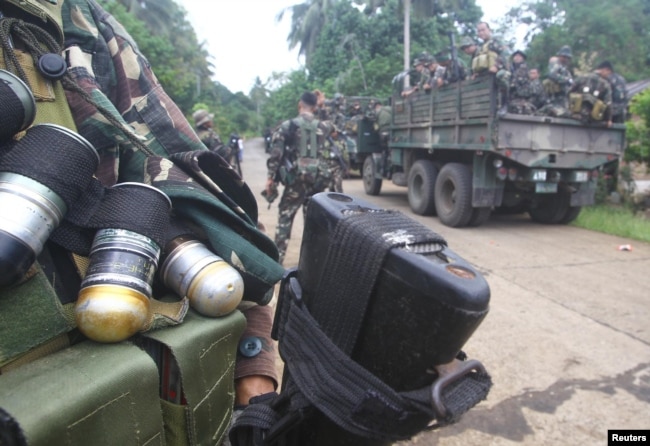 FILE - Soldiers stand guard on a road as they are deployed to remote villages in Jolo, Sulu southern Philippines, Oct. 17, 2014.