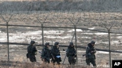 Binh sĩ Nam Triều Tiên tuần tra dọc hàng rào biên giới ở làng Bàn Môn Ðiếm, ngày 11/3/2013.