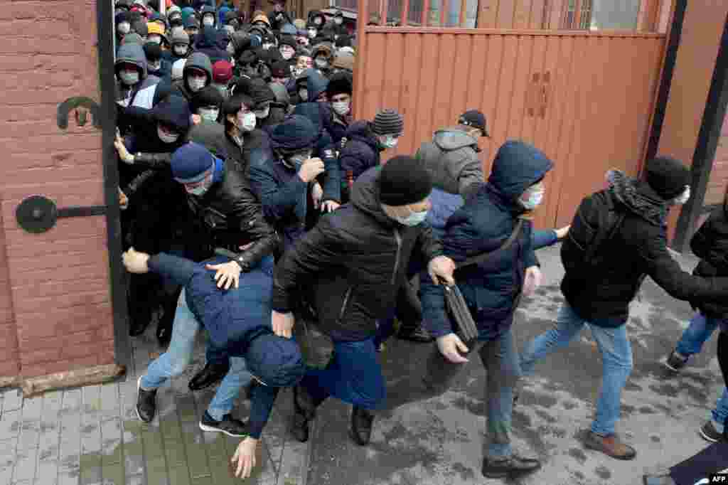 Migrants wearing protective face masks hurry to renew work and residence permits amid the spread of the novel coronavirus (COVID-19), at a migration center in Saint Petersburg, Russia.