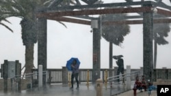 Beachgoers get caught in a sudden downpour when a band associated from Tropical Storm Colin came ashore at Clearwater Beach in Clearwater, Florida, June 6, 2016. 