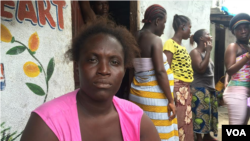 Ebola survivor Finda Fallah sits in front of her new room in West Point, Monrovia. (Benno Muchler/VOA)