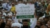 FILE - A Pakistani holds a placard that reads "Terrorists should be punished," during a protest to condemn a series of suicide bombings, in Karachi, Feb. 19, 2017. Sindh provincial counterterrorism authorities are concerned about a trend among educated youth resort to militancy and extremism.