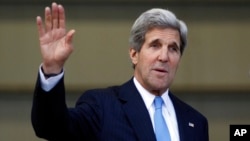 U.S. Secretary of State John Kerry waves to journalists after a press conference at the headquarters of the Colombian National Police Counter-Narcotics in Bogota, Aug. 12, 2013.