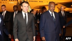 French president Emmanuel Macron (C) is welcomed by Djibouti's president Ismail Omar Guelleh upon his arrival at Djibouti's airport, March 11, 2019, in Djibouti, at the start of his trip to eastern Africa