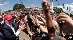 FILE - Republican presidential candidate Donald Trump greats the crowd at the Iowa State Fair in Des Moines, Aug. 15, 2015.