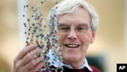 Richard Henderson, one of the 2017 Nobel Prize winners in Chemistry, holds a bacterio rhodopsin model prior to a press conference at the Laboratory of Molecular Biology in Cambridge, England, Wednesday, Oct. 4, 2017. 