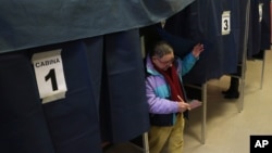 A man exits a polling booth after casting his ballot in Milan, Italy, February 24, 2013.