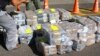 FILE - Costa Rican police officers guard about two tons of cocaine in this handout photo provided by Costa Rica's Ministry of Public Security, Feb. 1, 2012. A cocaine-smuggling operation at the international airport in San Juan, Puerto Rico, has led to 12 suspects being indicted.