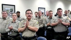 Maricopa County Sheriff's Office jail officers, who lost their federal power to check whether inmates are in the county illegally, give Sheriff Joe Arpaio a standing ovation after they turned in their credentials when federal officials pulled the Sheriff'