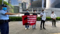 多名民主派区议员8月7日下午到政府总部”公民广场”外召开记者会，抗议特首林郑月娥聘用3间中资化验所进行全民病毒检测，有警员上前警告他们涉嫌违反公众地方不可以超过2人聚集的防疫”限聚令”。 (美国之音汤惠芸拍摄)